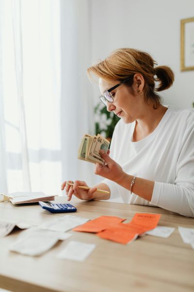 Woman counting money on calculator